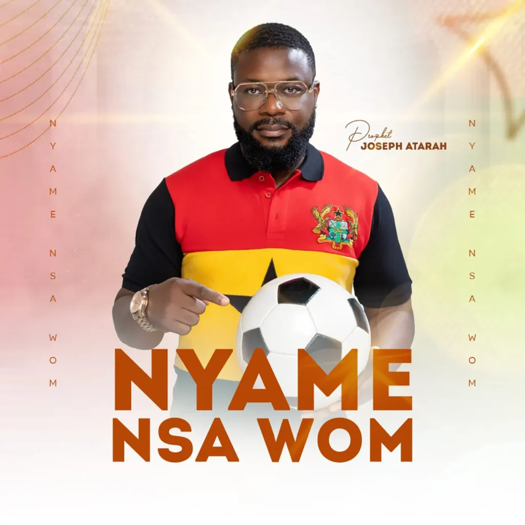 Portrait of a bearded man with glasses in a red-yellow-black polo, holding a soccer ball; bold poster text reads 'NAME NSA WOM' behind him.